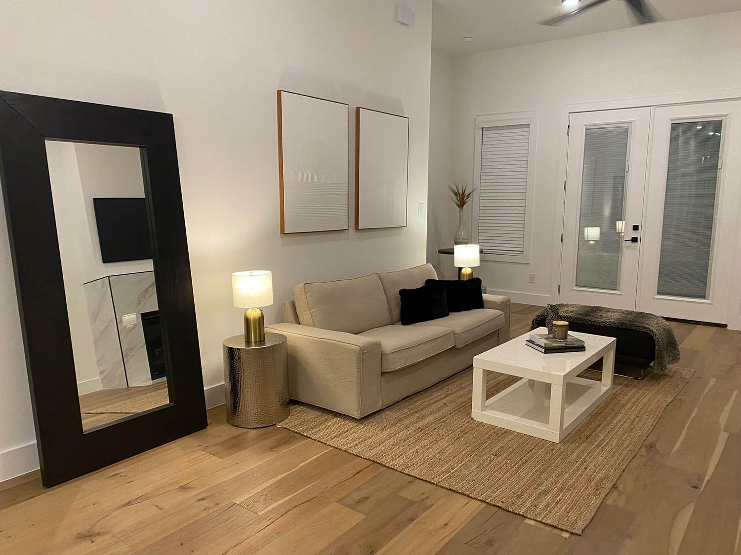 Staged living room with oversized floor mirror and neutral furniture by Eleven 11 Home Staging