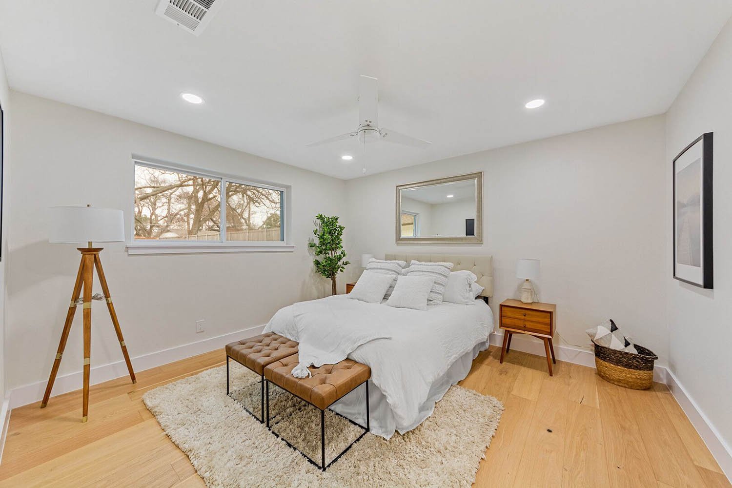 Staged bedroom with white bedding, bench, and tripod lamp by Eleven 11 Home Staging, Dallas-Fort Worth
