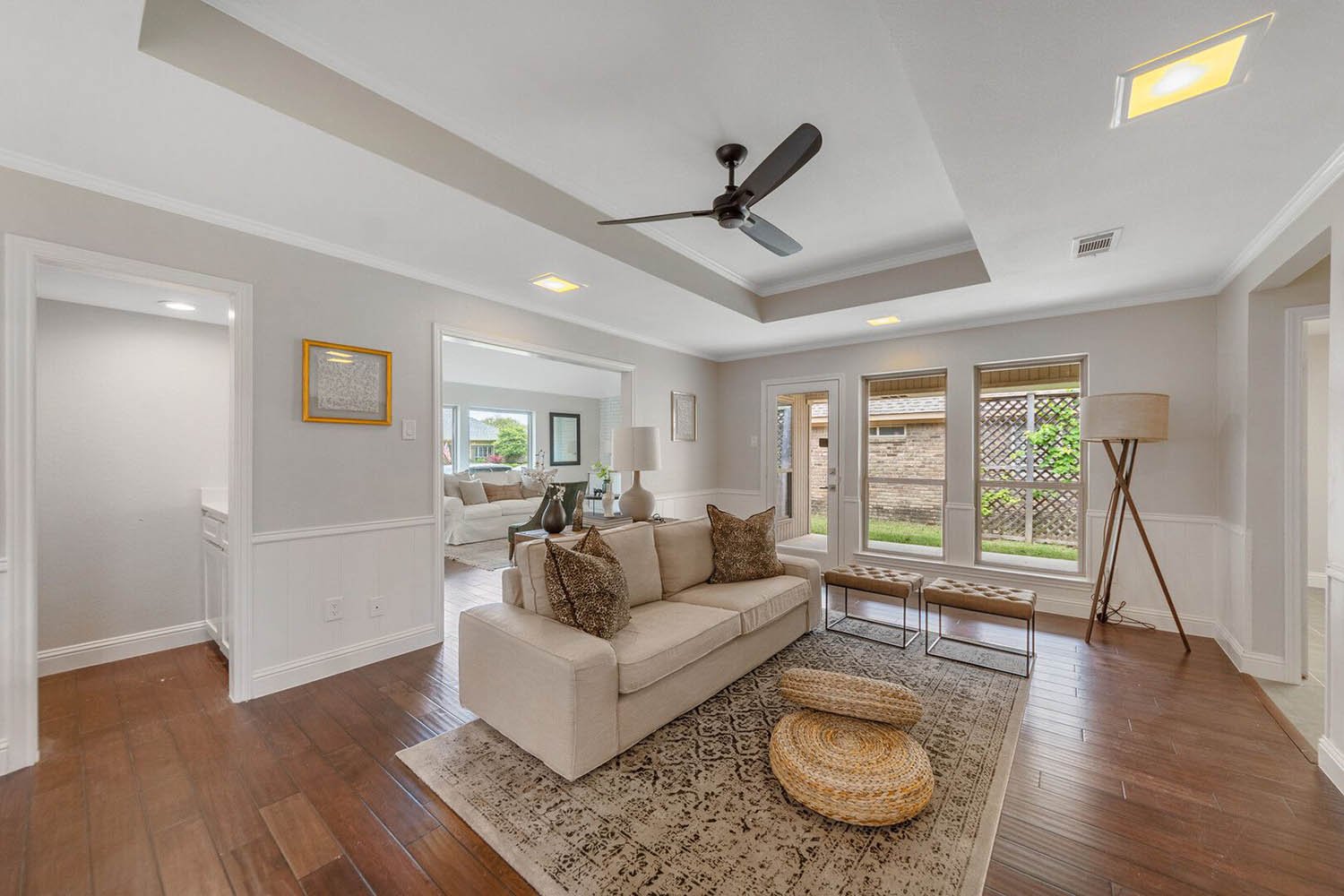 Living room staged by Eleven 11 Home Staging in Dallas-Fort Worth, Texas: cream sectional, layered rug, and warm natural light
