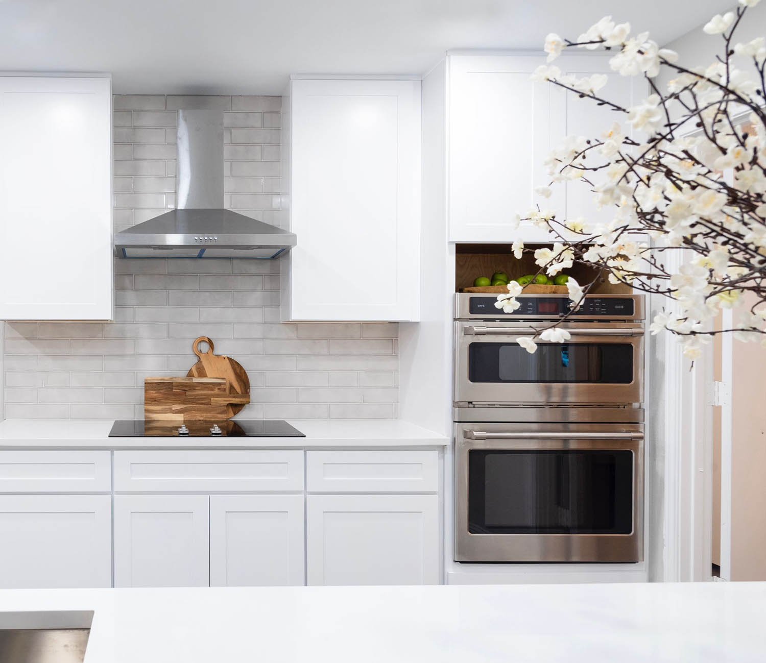 Bright white kitchen styled with blossom branches for a DFW listing by Eleven 11 Home Staging